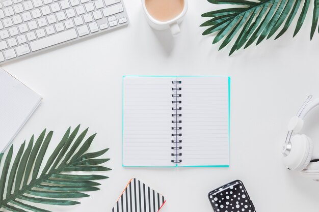 Opened notebook near gadgets and palm trees