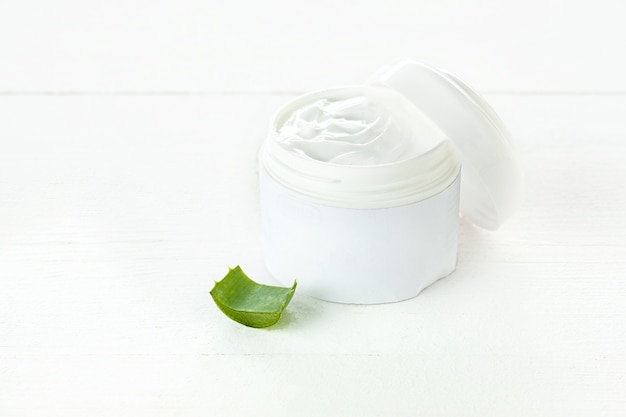 Opened plastic container with cream and aloe