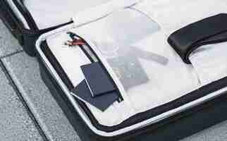 Free photo opened suitcase with passports watch and tie