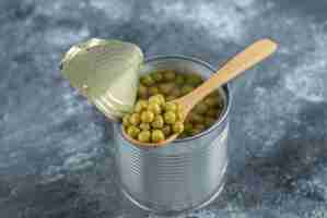 Free photo opened tin green peas and wooden spoon.