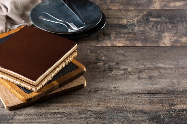 Opera cake dessert slice on wooden table