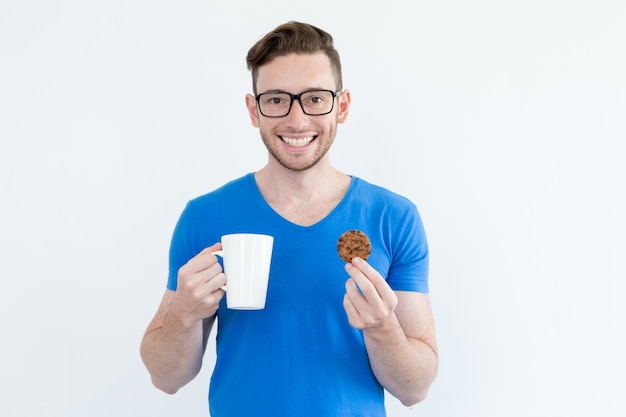 クッキーとコーヒーを飲む楽観的な男