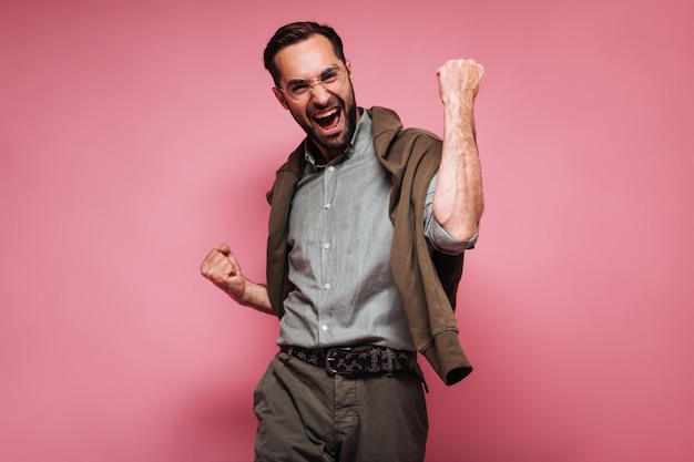 Optimistic guy in glasses and short rejoices in victory