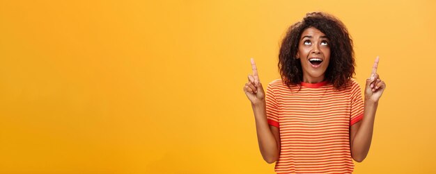 Optimistic happy african american girl saying thanks to god looking and pointing up pleased and care