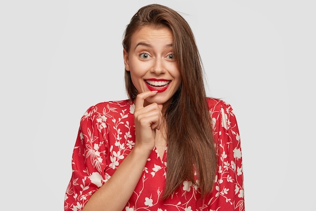 Optimistic happy European woman wears red lipstick, looks joyfully