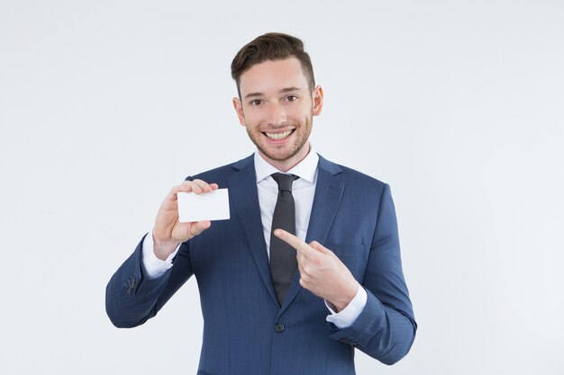 Optimistic male manager pointing at business card