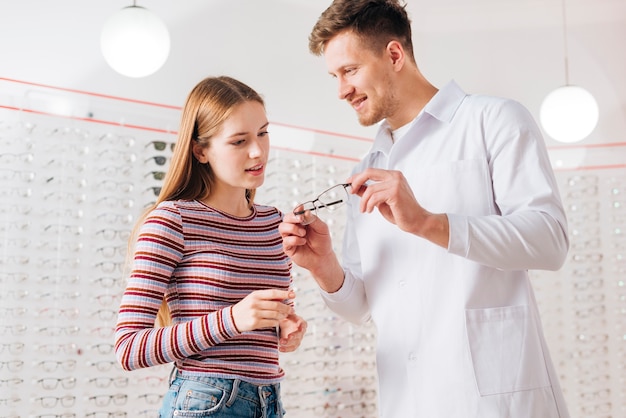 Foto gratuita optometrista che consiglia donna che sceglie i vetri