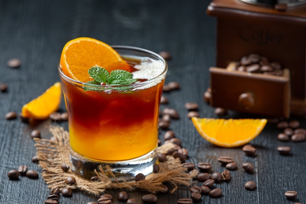 暗い表面にオレンジとコーヒーのカクテル。