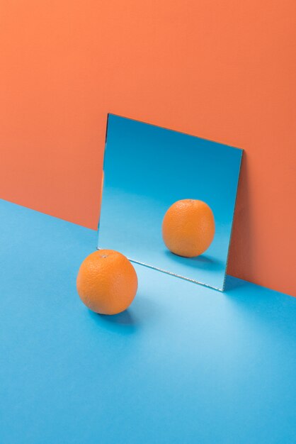 オレンジに分離された青いテーブルの上のオレンジ