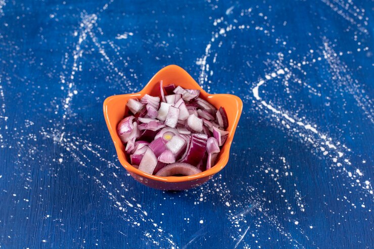मुफ़्त फोटो orange bowl of sliced purple onions on marble surface