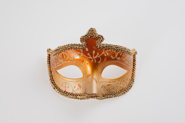 Orange carnival mask on white table