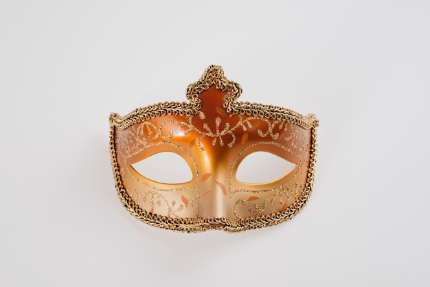 Orange carnival mask on white table