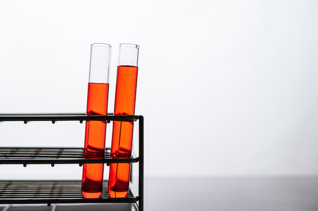 Orange chemicals in a science glass tube arranged on a shelf