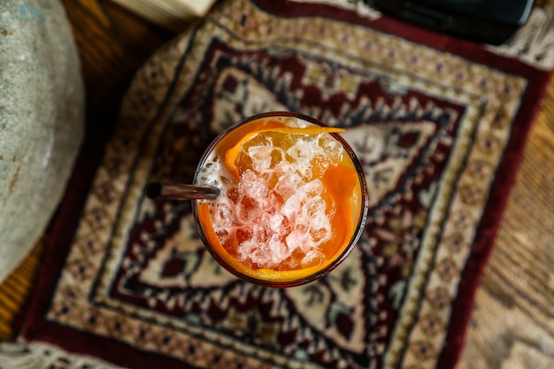 Free photo orange cocktail peals ice sparkling water syrop top view