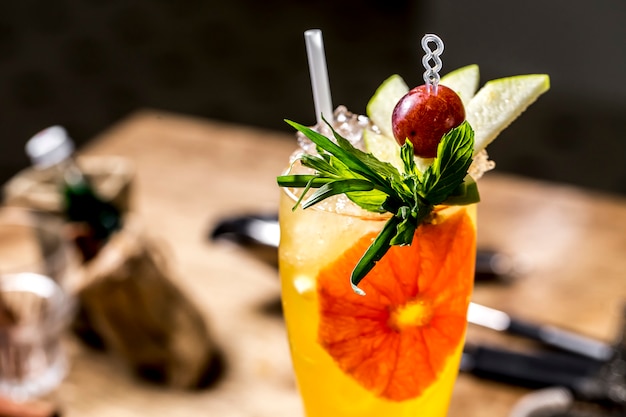 Orange cocktail with tarragon grape mint apple side view