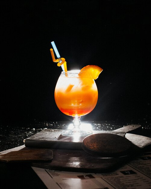 orange coctail with fresh orange juice ice and straws on book