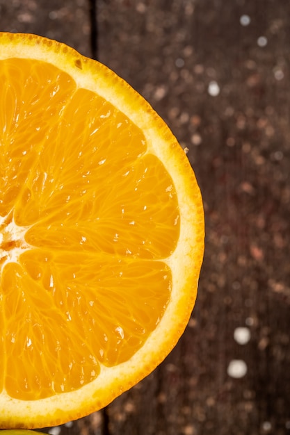 Orange cut in half on a wooden table