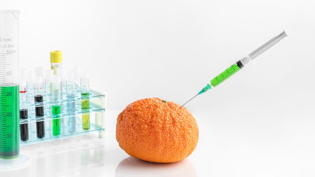 化学物質で満たされた注射器で机の上のオレンジ