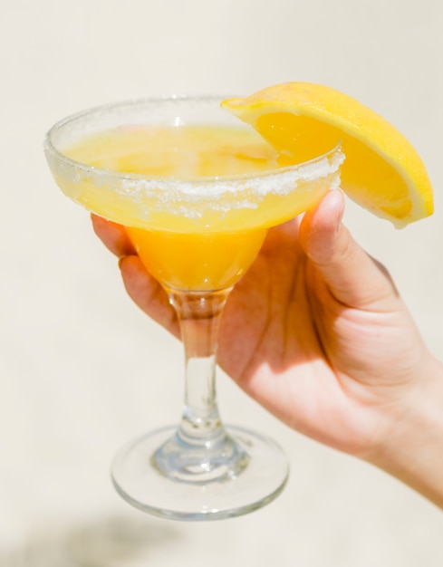 Orange drink in glass in hand