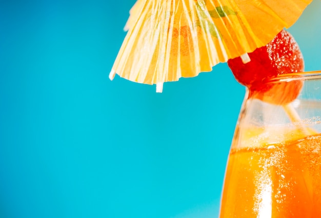 Free photo orange drink with strawberry in umbrella decorated glass