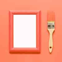 Free photo orange empty frame and wood paintbrush