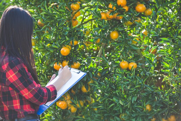 Orange girl farmer holding empty form in hand.