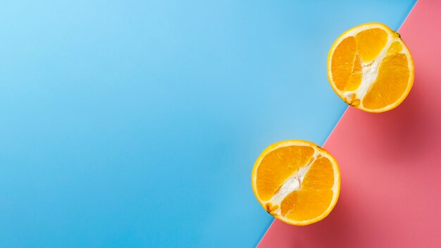 Orange halves on coloured background