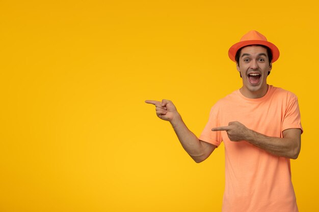 Orange hat handsome pretty guy in orange tshirt with the hat with wide open mouth pointing to left