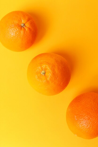 Апельсин, изолированные на оранжевой поверхности