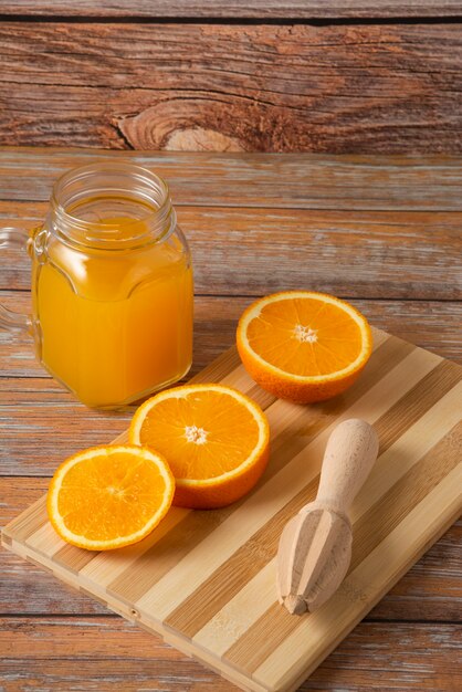 木製のテーブルの上のガラスの瓶にオレンジジュース