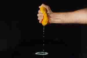 Бесплатное фото Апельсиновый сок брызгает от половины фруктов в руке человека