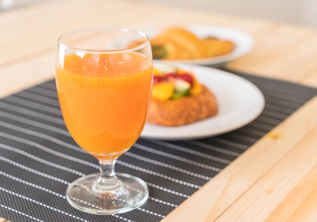 Free photo orange juice with spinach croissant and mixed fruits danish