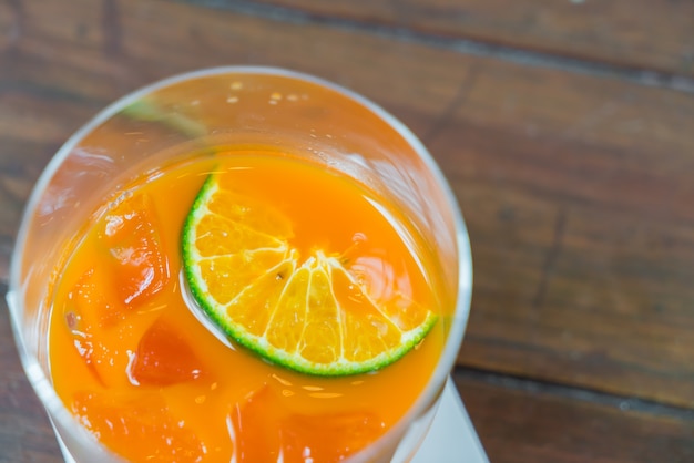 木製のテーブルの上にオレンジジュース。