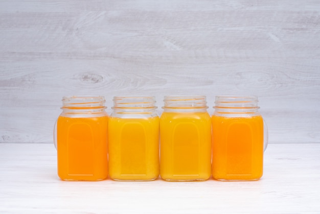 Orange and lemon juice in glasses on white table