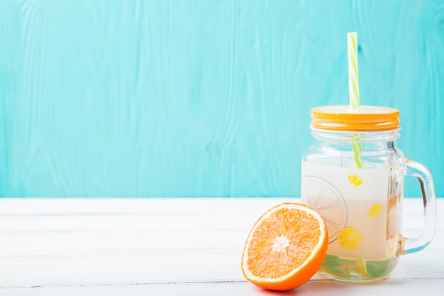 Free photo orange near glass with straw and lemonade