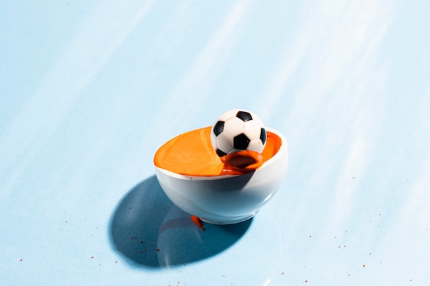 Free photo orange paint splash with soccer ball