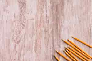 Free photo orange pencils on wooden surface