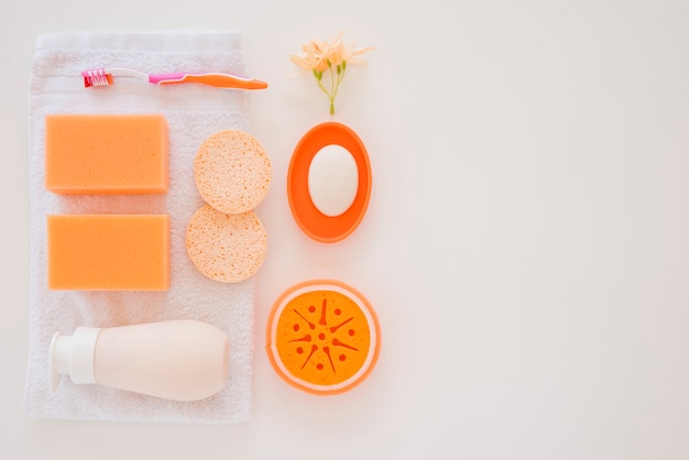 Бесплатное фото Оранжевые средства личной гигиены на белом полотенце