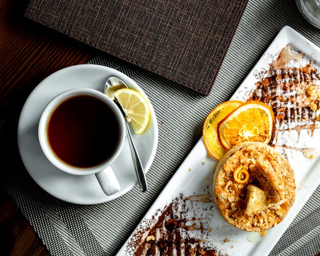 Orange pie and a cup of black tea with lemon slice