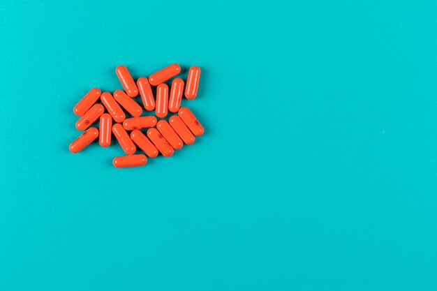 Orange pills on cyan surface