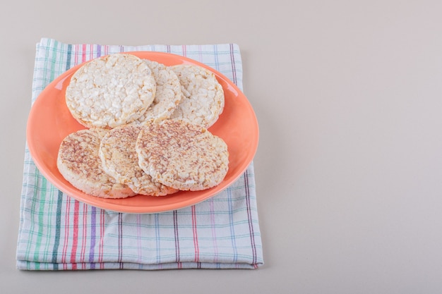 Orange plate of delicious rice cakes on white table. High quality photo