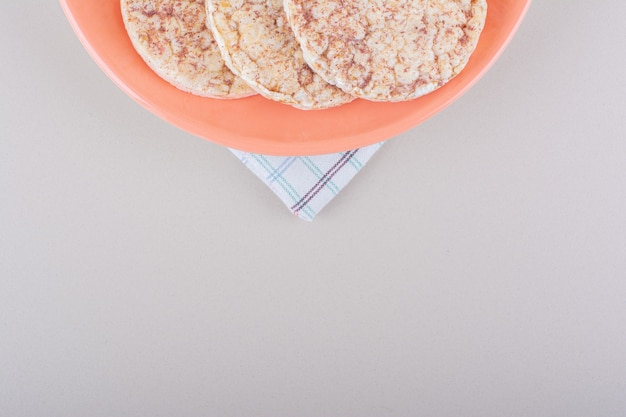 Orange plate of delicious rice cakes on white table. High quality photo