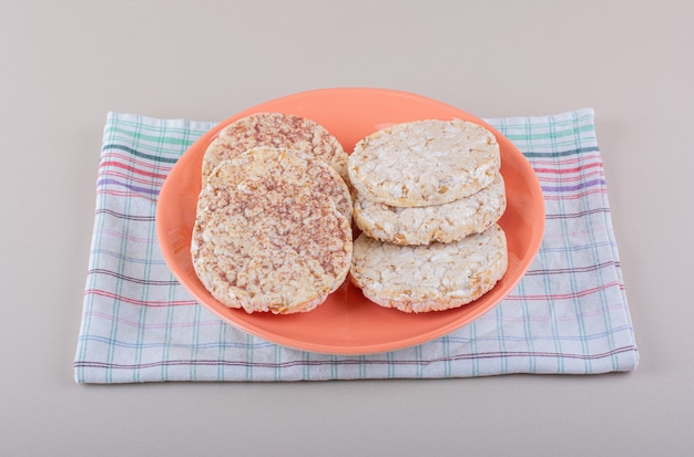 Orange plate of delicious rice cakes on white table. High quality photo