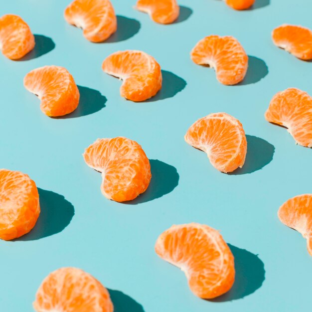 Orange slices on blue background high angle