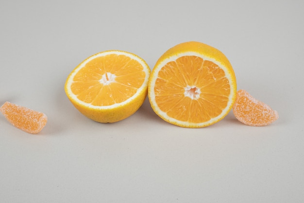 Orange slices and jelly candies on beige surface