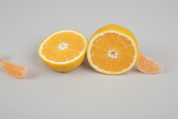 베이지 색 표면에 오렌지 슬라이스와 젤리 사탕