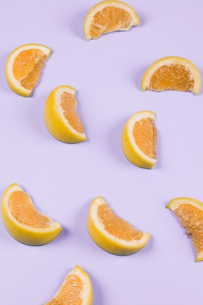 Free photo an orange slices on purple background