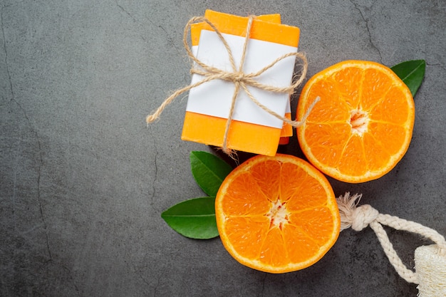 Orange soap with fresh orange on dark background