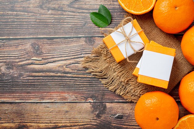 Orange soap with fresh orange on dark wooden background