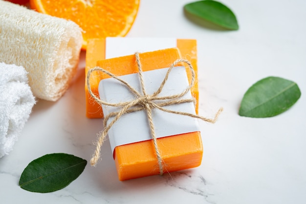 Free photo orange soap with fresh orange on marble background